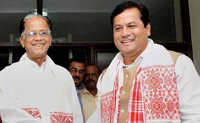 Sarbananda Sonowal, wearing a traditional gamosa, smiles beside former Chief Minister Tarun Gogoi